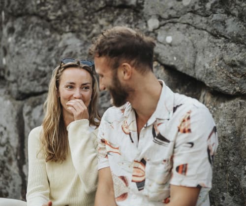 Kvinna och man tittar på varandra och fnissar.