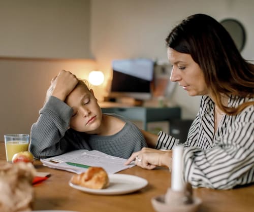 Mamma och son läser läxor tillsammans.