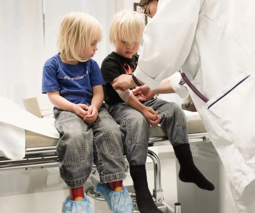 Barn som blir ompysslade av en läkare.