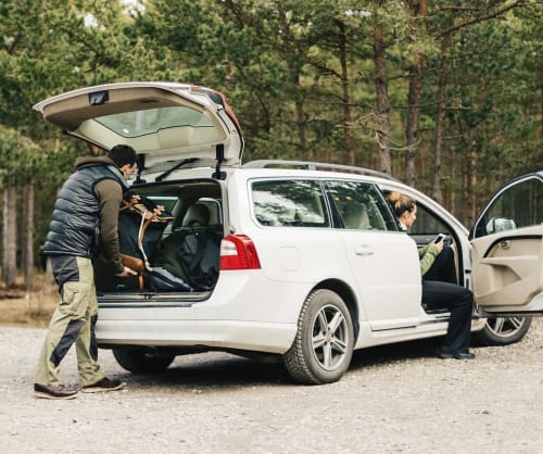 Par som ska åka på bilresa och packar en vit Volvo. ICA Banken har lån till köp av bil.