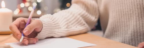 Person som skriver en önskelista till jul.