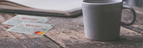 Två kort på ett cafébord - bankkort eller kreditkort