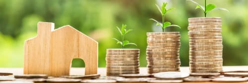 Hus med pengar staplade bredvid