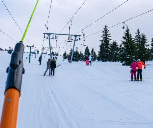 Skidlift med folk som åker släpliftar i fjällen.