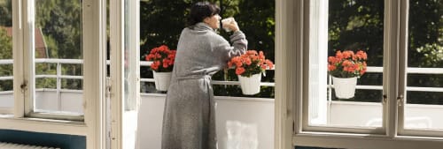 Kvinna står på en balkong. Mest köpta fonderna bland ICA Bankens kunder.