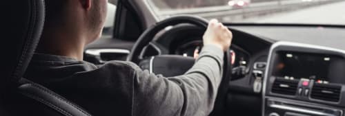 Man som kör en bil på motorvägen. Tips vid köp av begagnad bil.