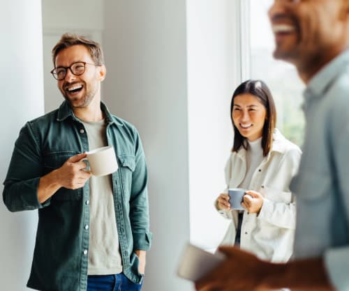 Personer på ett kontor som fikar och pratar med varandra.