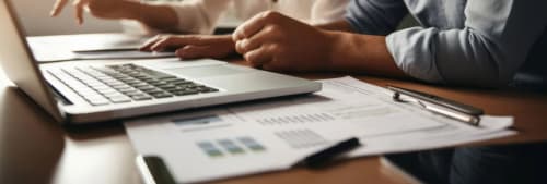 Bild på ett par som går igenom sin ekonomi framför en dator