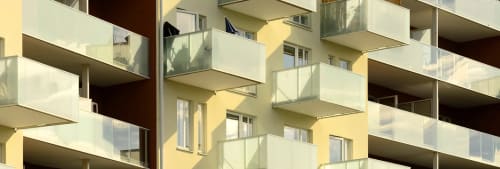 Lägenhetshus med stora och små balkonger.