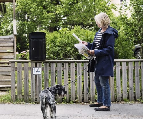 Kvinna med hund som öppnar posten.