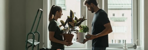 Man och kvinna plockar prylar i sin lägenhet.