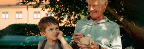 En äldre man äter glass med sitt barnbarn