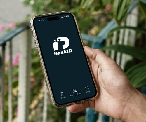 En hand som håller en mobil som visar appen med Mobilt BankID.