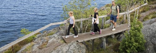 Familj på promenad vid havet. 20 spartips för semestern.