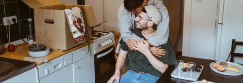 Ett par kramas i köket i sin nya lägenhet