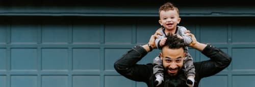 Pappa med barn på axlarna