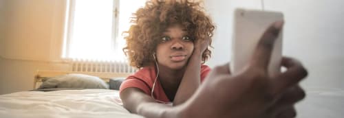 Tjej tittar oroat på mobilen