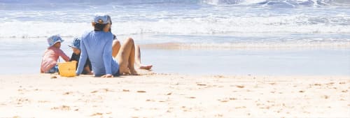 Billiga sommaraktiviteter. En barnfamilj på en strand vid havet.