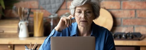 Kvinna vid laptop i köket