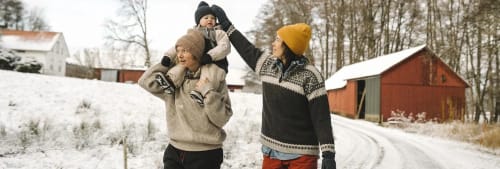 Två kvinnor och ett barn på vinterpromenad.