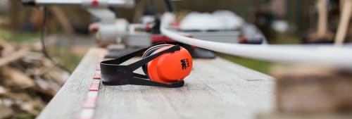 Hörlurar och byggmaterial på en bräda för att finansiera renovering.