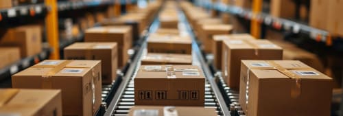 Paket på ett lager som åker på ett rullande band.