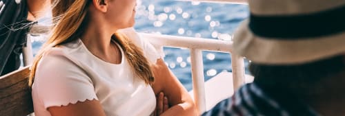 En kvinna som tittar ut över glittrande vatten.