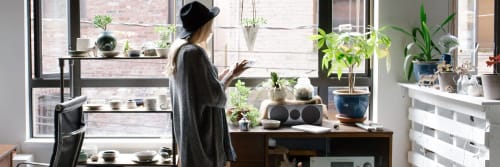 Tjej som står vid fönstret i en studentlägenhet