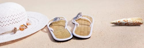 Sandstrand med tofflor, snäcka och en solhatt - Semestertips
