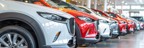 Bilar som står på rad i en bilhall.