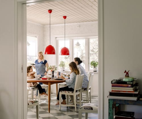 Familj som sitter runt ett matbord inne i ett kök.