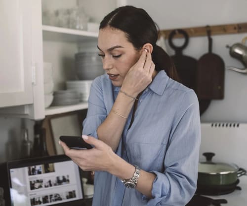 Kvinna som tittar på sin mobil.