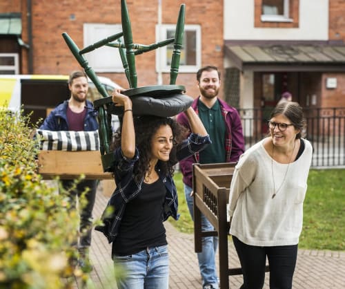 Kompisar som bär möbler från en flyttbil. Ansök om lånelöfte för bolån hos ICA Banken.