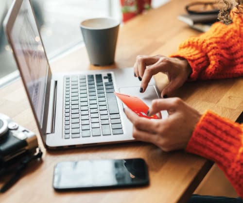 Kvinna betalar med ICA Bankens bankkort online.