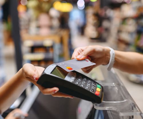 En person betalar med ICA Bankens kreditkort i en butik.