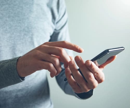 Man som trycker på skärmen på sin smartphone.