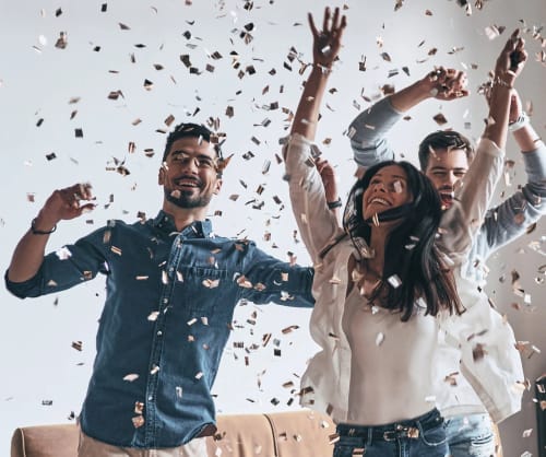 Glada personer i regn av konfetti.