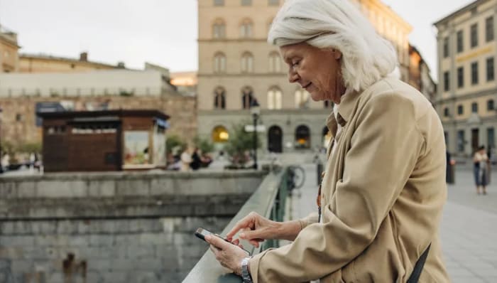 Kvinna som läser något på sin mobil.