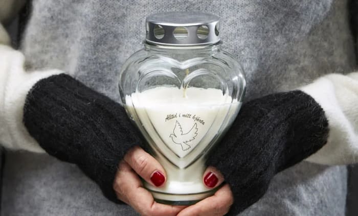 Kvinna som håller i ett gravljus