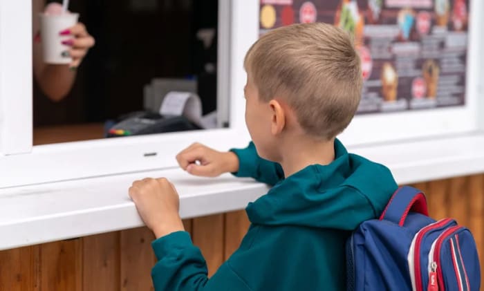 En pojke som handlar i en kiosk.