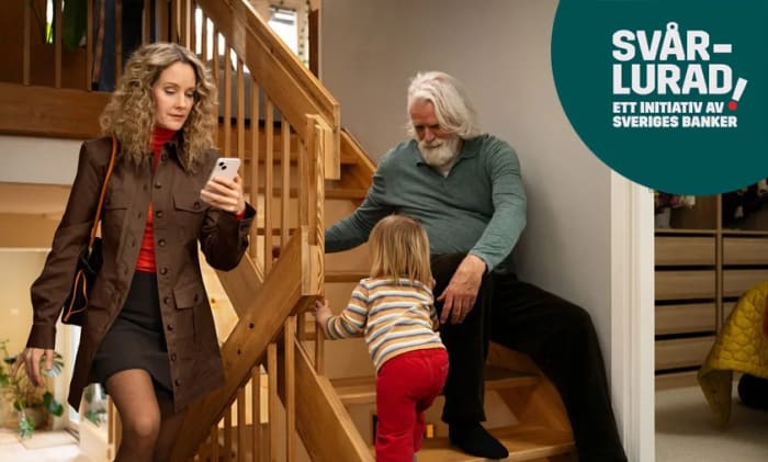 Kvinna som går uppför en trappa tittandes på mobilen och en äldre man sitter med ett ett barn i en trappa bredvid.