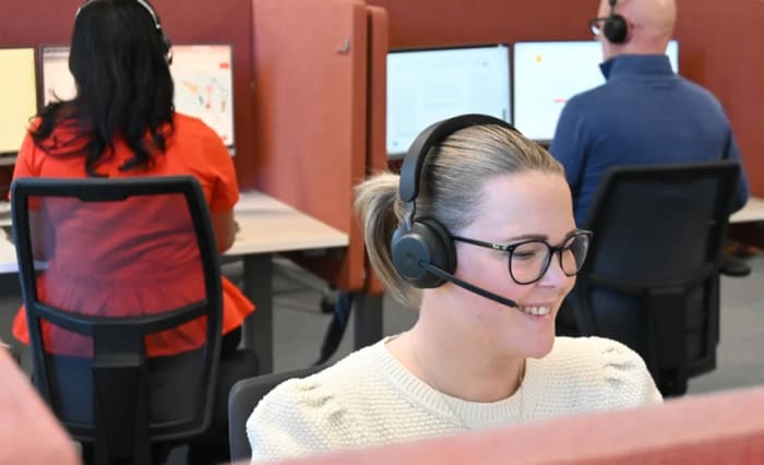 Privatrådivare på kundservice som talar i telefon och hjälper kunder.