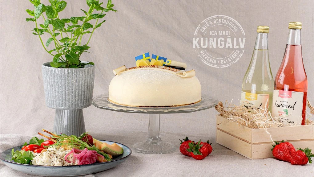 Catering. Vit prinsesstårta formad som en studentmössa på ett fat. Intill står en grilltallrik.