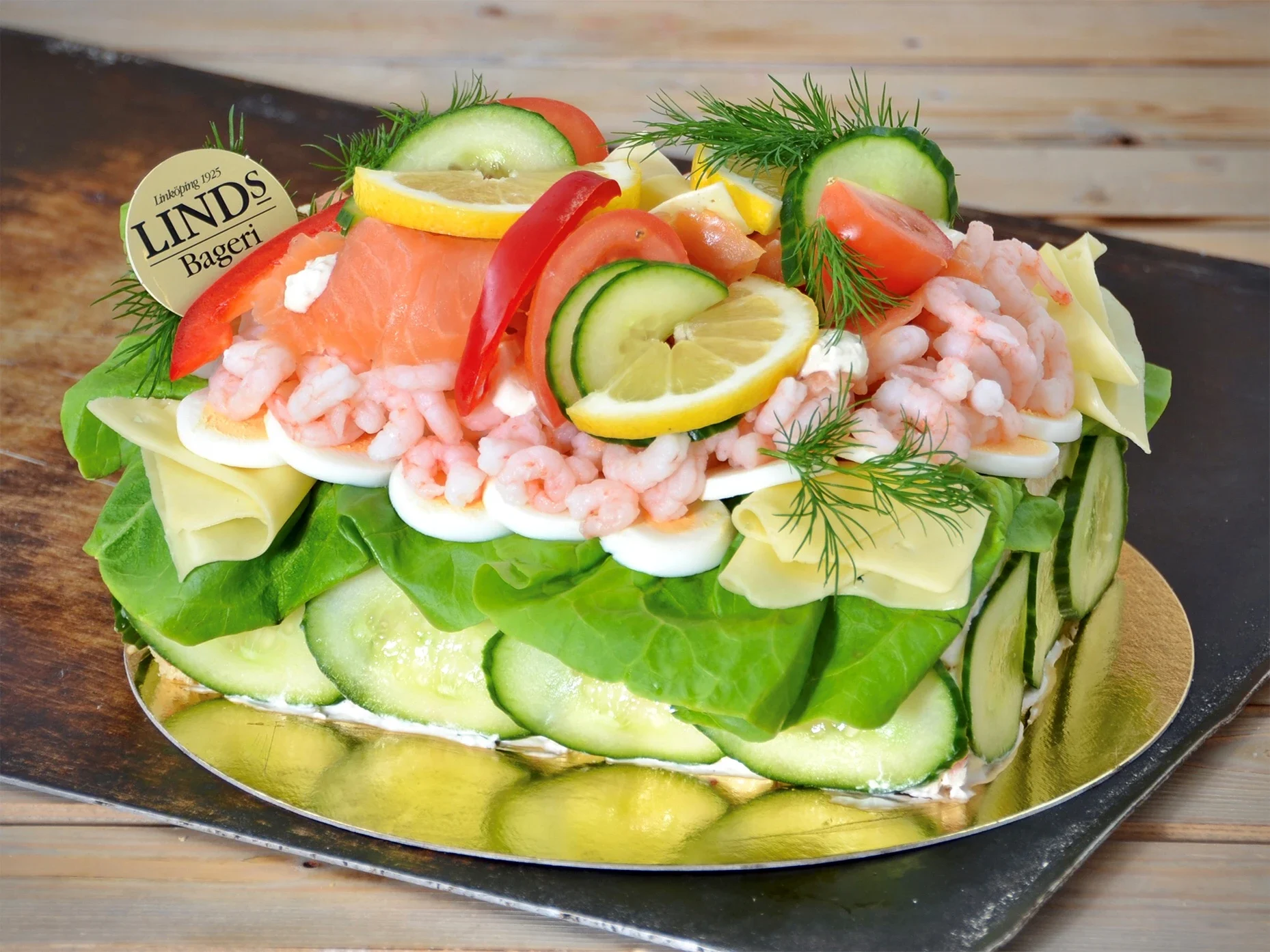 Fyllning av skagenröra och räksallad. Dekorerad med kallrökt lax, räkor, ost, pepparrotsgrädde, sallad och grönsaker. Franskbottnar med vete och rågmjöl. (Innehåller: Gluten, Laktos, skaldjur, mjölk och ägg. Innehåller ej: Fläsk)