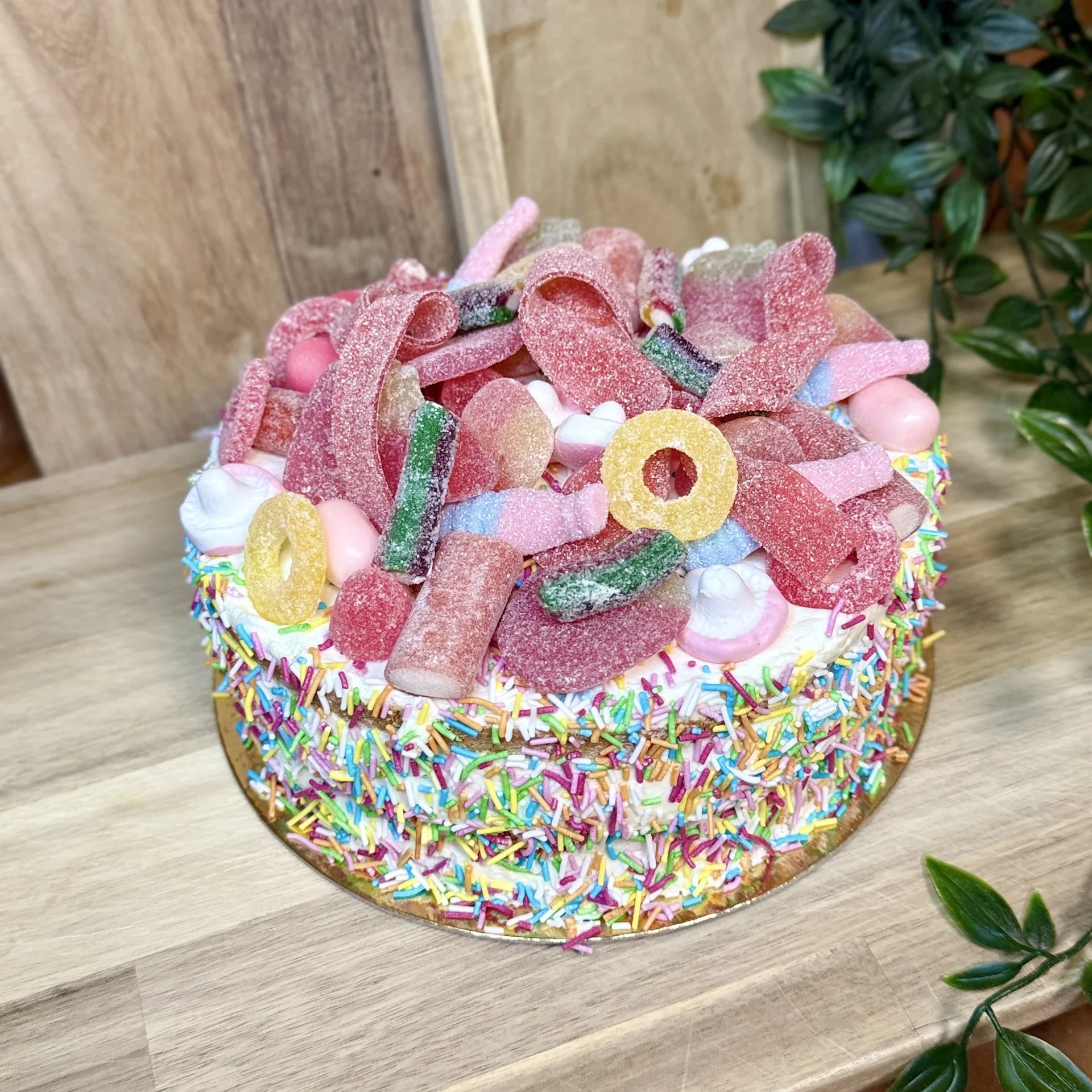 Gottegrisens drömtårta! Sockerkaksbotten, hallonsylt, vaniljkräm, grädde toppad med blandat godis och färgglatt strössel.