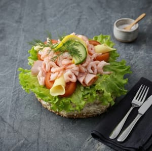 Lyxig Räkbomb (ca 1200g) – En klassiker med extra allt! Njut av vår handgjorda räkbomb fylld med en krämig skagenröra på surdegsbotten, toppad med hela 15 % handskalade räkor (Pandalus borealis). Denna generösa skapelse bjuder på en perfekt balans mellan sälta och sötma, rikligt garnerad med mör skinka, krämig ost, friska grönsaker, citron och färsk dill.  En smakrik festmåltid som räcker till flera eller för den riktigt hungrige!