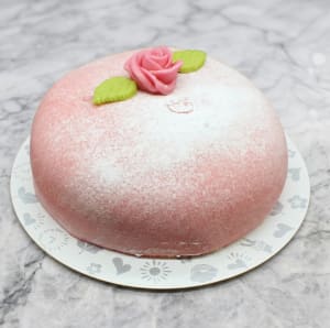 Klassisk kalastårta med rosa marsipan, fylld med hallonsylt, vaniljkräm ochvispgrädde. Dekorerad med vacker marsipanros och dubbla, handgjorda blad.