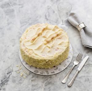En elegant Red Velvet Cake med djupt rött färgade bottnar, fylld och täckt med en vit frosting