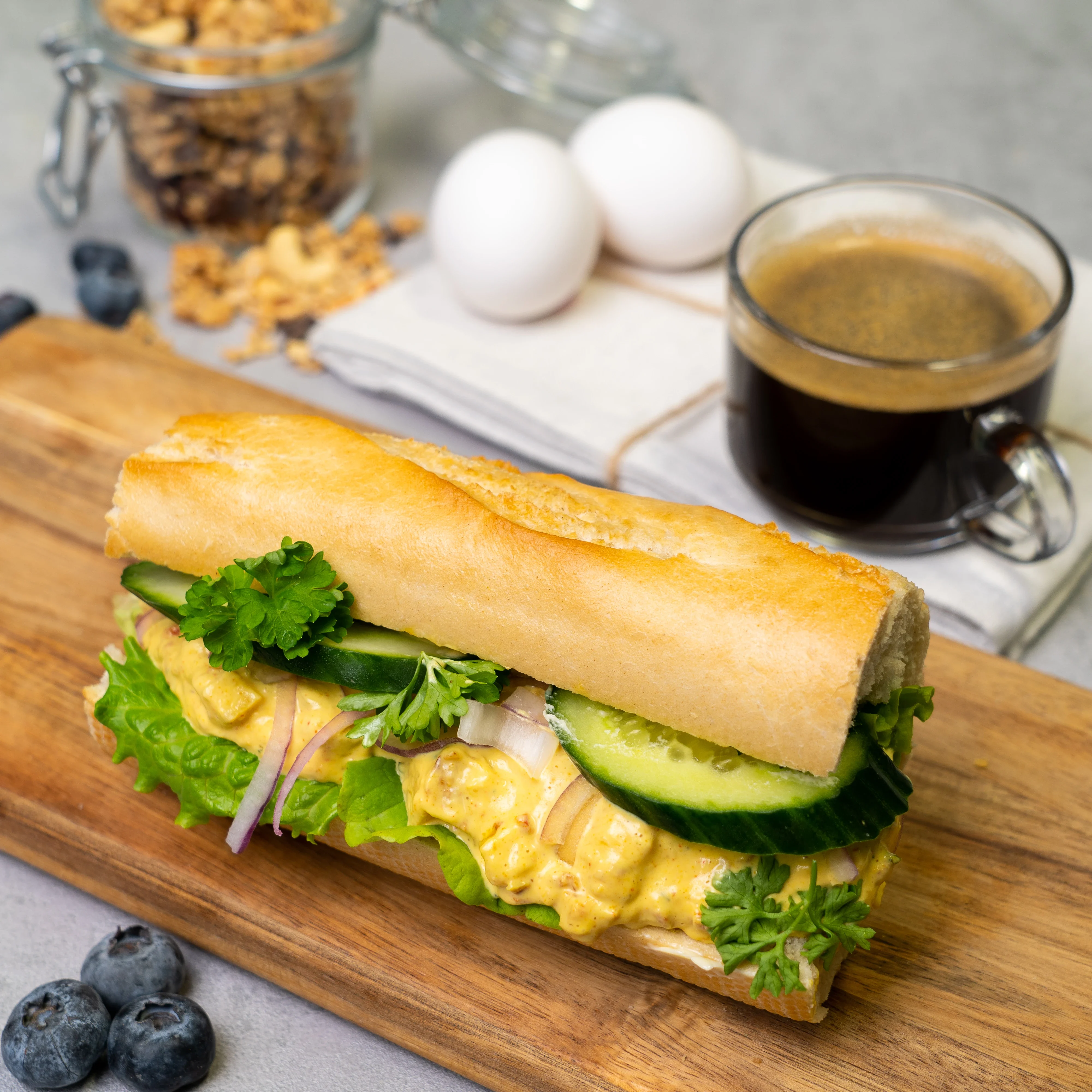 En baguette med kyckling- och curryrröra, sallad, gurka och rödlök.