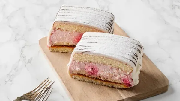 Mellan tre hembakta sockerkaksbottnar samsas vår egna vaniljkräm och fluffig grädde och rikligt med hallon.